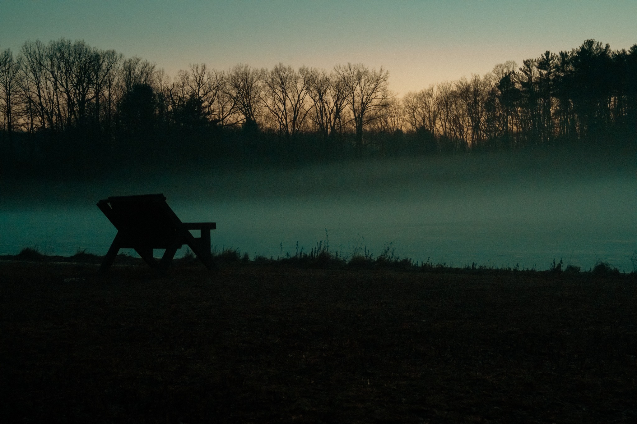 Bench beside misty water